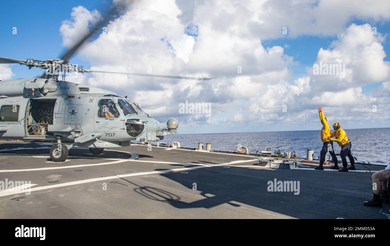 220912-N-NQ285-1360 OCÉAN ATLANTIQUE (SEPT 12, 2022) le compagnon de Boatswain 3rd classe John Strand, à gauche, Et le Mate 2nd de Boatswain Antwan Johnson, tous deux affectés au destroyer de missile guidé de classe Arleigh Burke USS Ramage (DDG 61), au signal d’un hélicoptère MH-60R Sea Hawk, attaché au Spartiate de l’Escadron d’attaque maritime (HSM) 70, pendant les opérations de vol pour l’entraînement tactique avancé de surface Warfare (SWATT), 12 septembre 2022. Ramage est en cours dans le cadre du groupe de grève Gerald R. Ford Carrier, qui mène des exercices SWATT afin d'accroître la létalité, d'assurer la préparation au combat et de faire du bal Banque D'Images