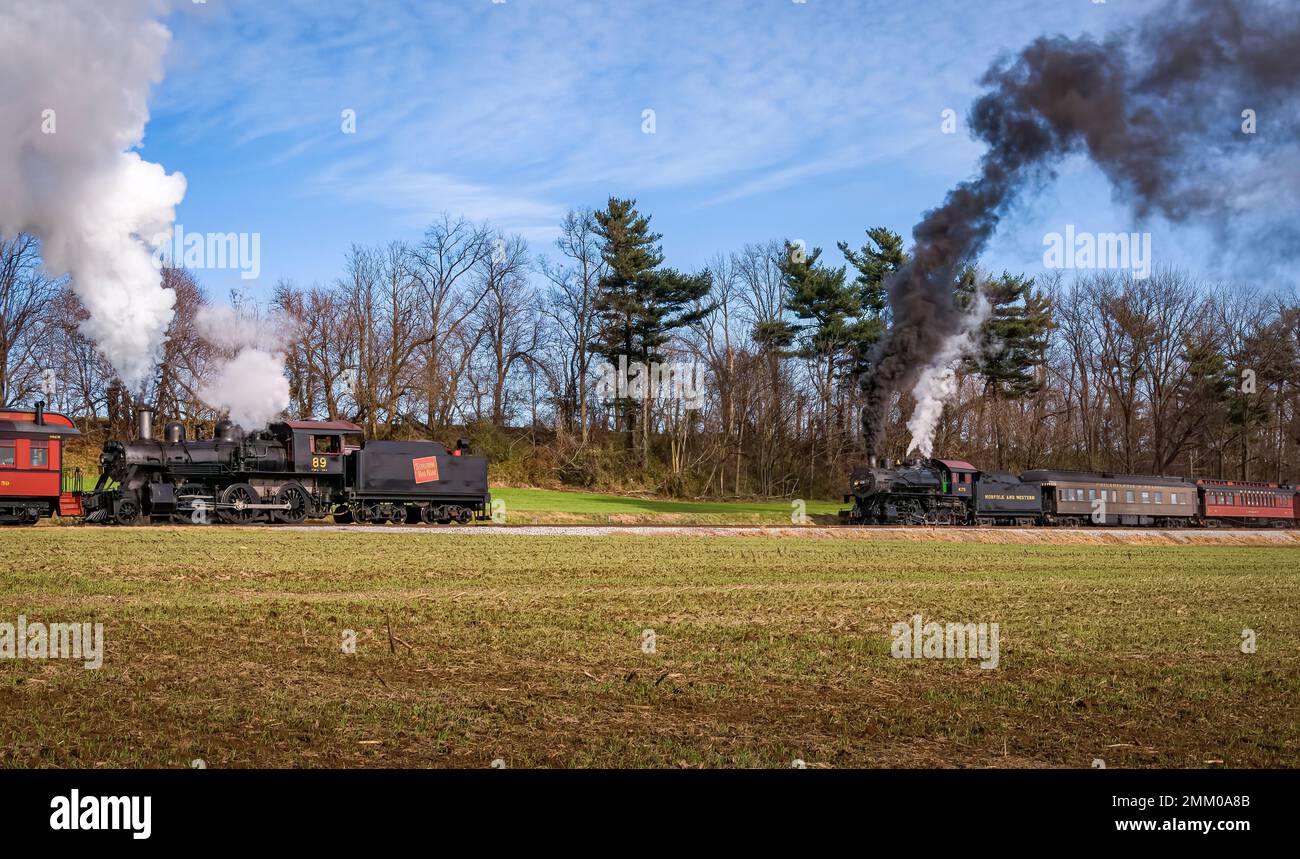 Ronks, Pennsylvanie, 4 décembre 2022 - Vue sur deux trains de voyageurs à vapeur classiques, qui soufflent beaucoup de fumée et de vapeur, tout en voyageant dans la campagne le jour de l'automne Banque D'Images