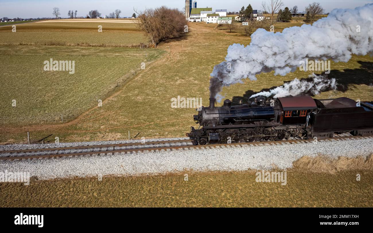 Vue aérienne parallèle d'un train de passagers à vapeur antique restauré qui se déplace à travers la campagne lors d'une Sunny automne Banque D'Images