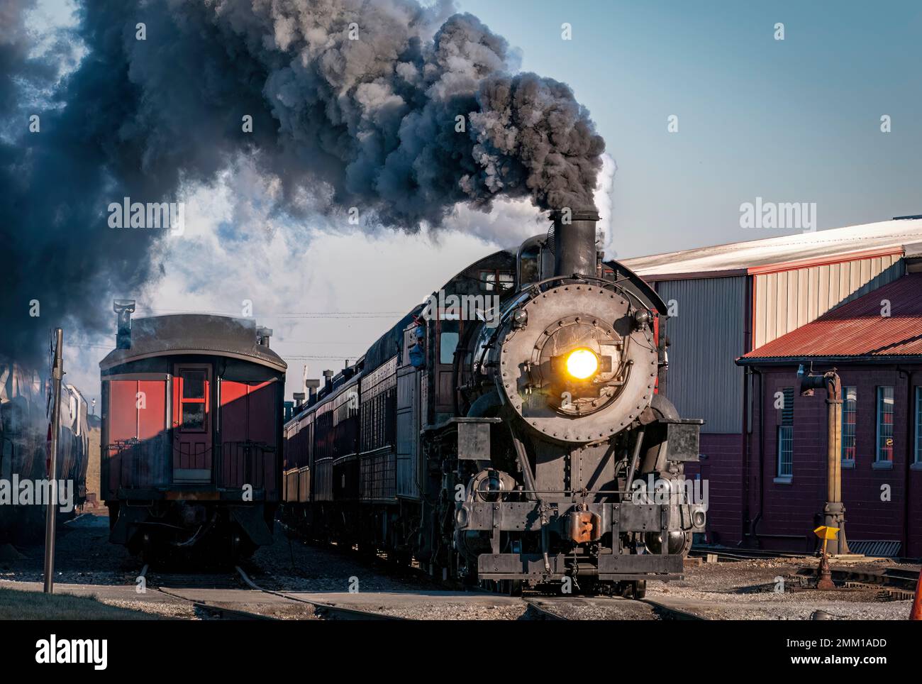 Strasburg, Pennsylvanie, 28 décembre 2022 - Vue sur un train de voyageurs à vapeur classique arrivant dans une gare qui soufflait de fumée et de vapeur, le jour d'hiver Banque D'Images