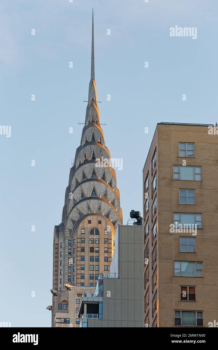 Vue en début de matinée sur le Chrysler Building, site historique de New York, l'emblématique flèche art déco est bordée de rouge du soleil. Banque D'Images Vue en début de matinée sur le Chrysler Building, site historique de New York, l'emblématique flèche art déco est bordée de rouge du soleil. Banque D'Images