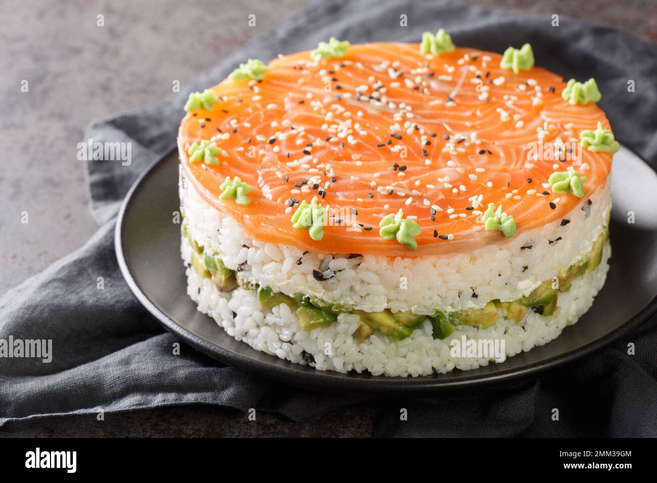 Gâteau de sushi au saumon, au riz, à l'avocat et au fromage de philadelphie, sur l'assiette de la table. Horizontale Banque D'Images