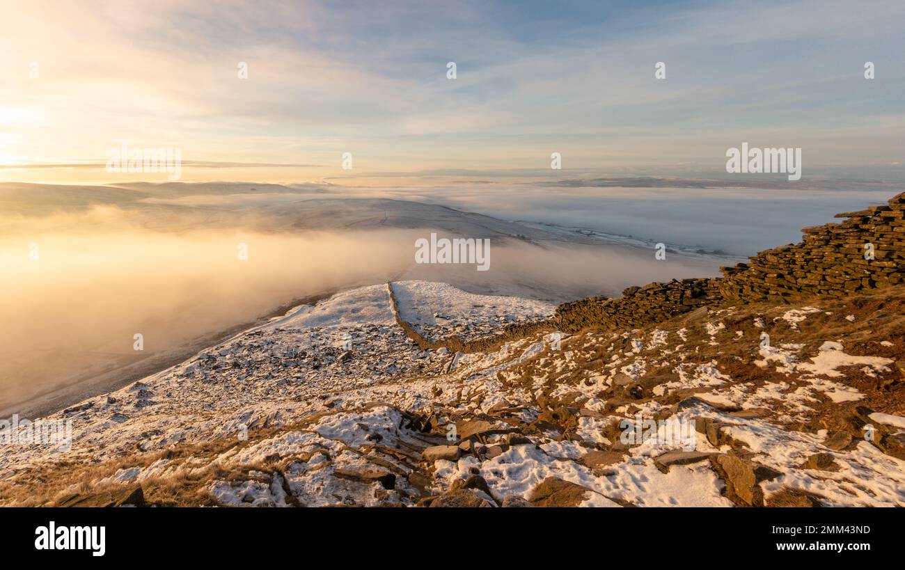 En regardant le mur de pierre vers le chemin final jusqu'au sommet de la montagne Pen-y-ghent au lever du soleil avec la brume et la neige dans le Yorkshire Dales NAT Banque D'Images