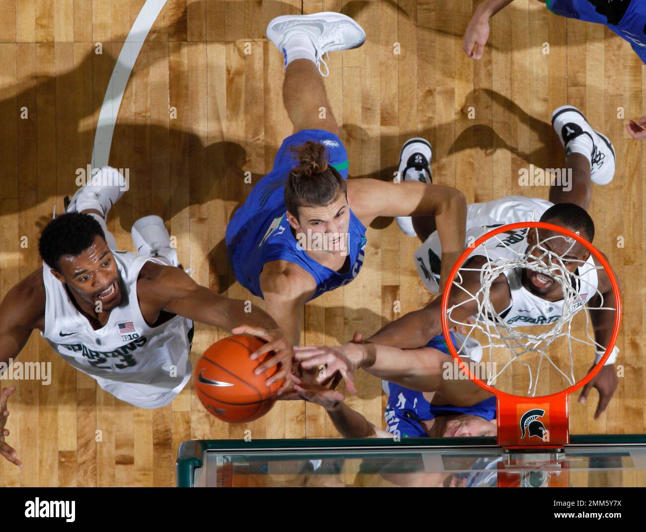 Michigan State's Xavier Tillman, left, Joshua Langford, right, and Florida Gulf Coast's Caleb Catto, center, and Ricky Doyle, bottom, reach for a rebound during the first half of an NCAA college basketball game, Sunday, Nov. 11, 2018, in East Lansing, Mich. Michigan State won 106-82. (AP Photo/Al Goldis) Banque D'Images