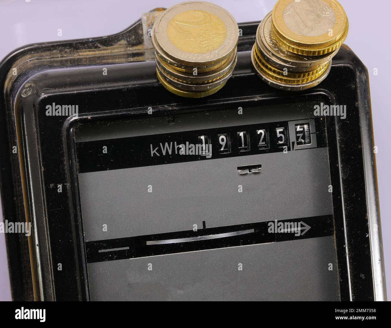 Compteur d'électricité et les pièces en euros ci-dessus avec le KWH Banque D'Images