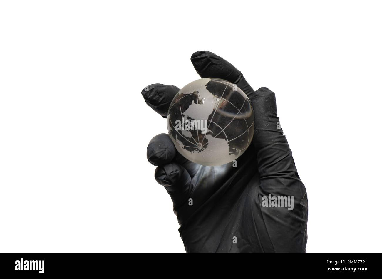 main dans des gants noirs tient un globe de planète en verre sur un blanc Banque D'Images