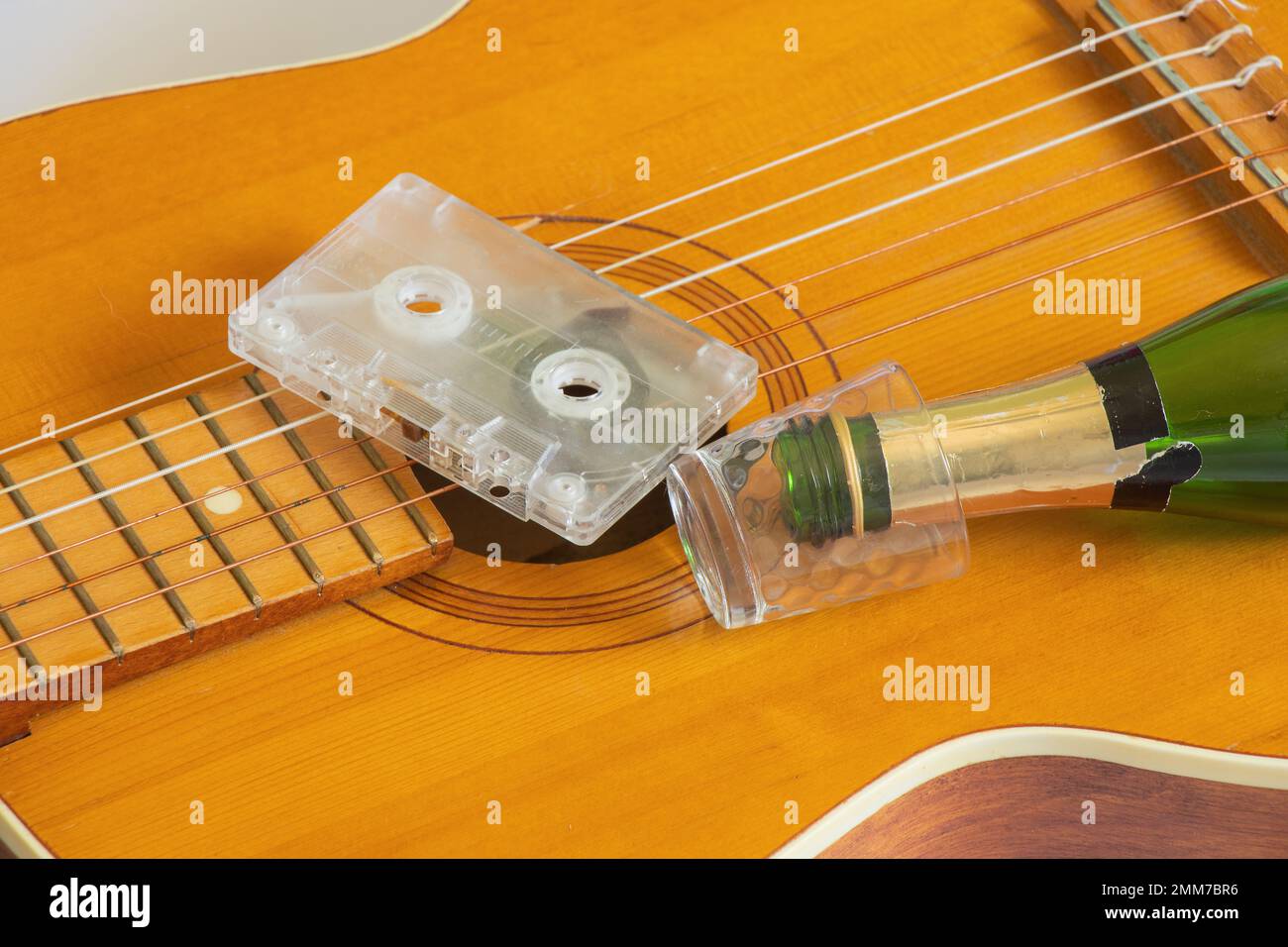 guitare et cassette de film sur un fond isolé une bouteille et un verre Banque D'Images