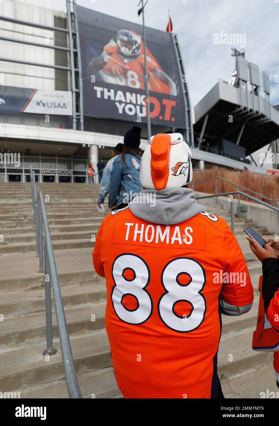 A Denver Broncos fan wears former Denver Broncos and current Houston Texans wide receiver Demaryius Thomas's jersey as he enters Mile High Stadium with a sign thanking Thomas for his years in Denver prior to an NFL football game, Sunday, Nov. 4, 2018, in Denver. (AP Photo/David Zalubowski) Banque D'Images