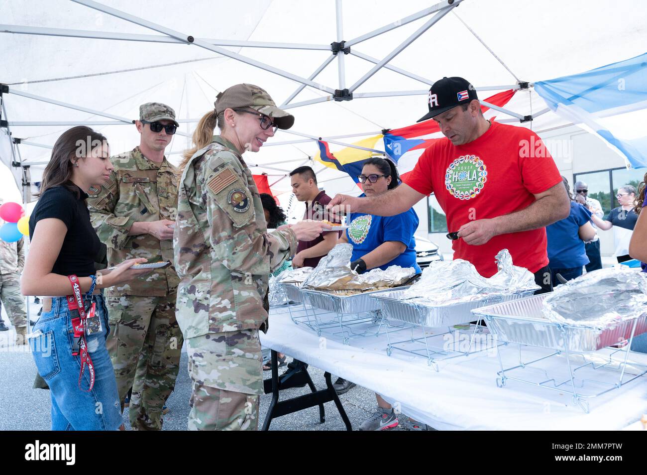 Sgt. Maître Anthony Velazquez, officier non commandant de l'escadre du transport aérien 436th en charge des inspections et des exercices, sert des échantillons de cuisine portoricaine aux participants de la partie bloc du mois du patrimoine hispanique sur la base aérienne de Douvres, Delaware, le 15 septembre 2022. La fête a présenté de la nourriture, des tables de démonstration de la culture latino-américaine et des DJ jouant de la musique latino-américaine. Banque D'Images
