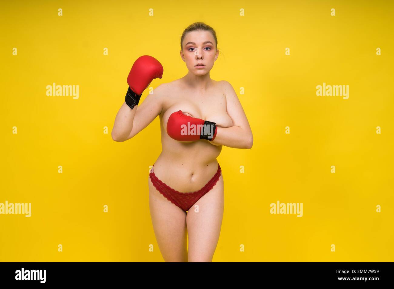Séduisante confiante boxer femme avec des gants studio, femme sportive posant regardant l'appareil photo. Banque D'Images