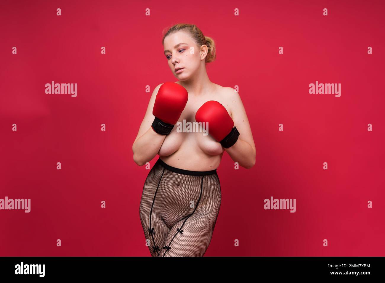 Séduisante confiante boxer femme avec des gants studio, femme sportive posant regardant l'appareil photo. Banque D'Images