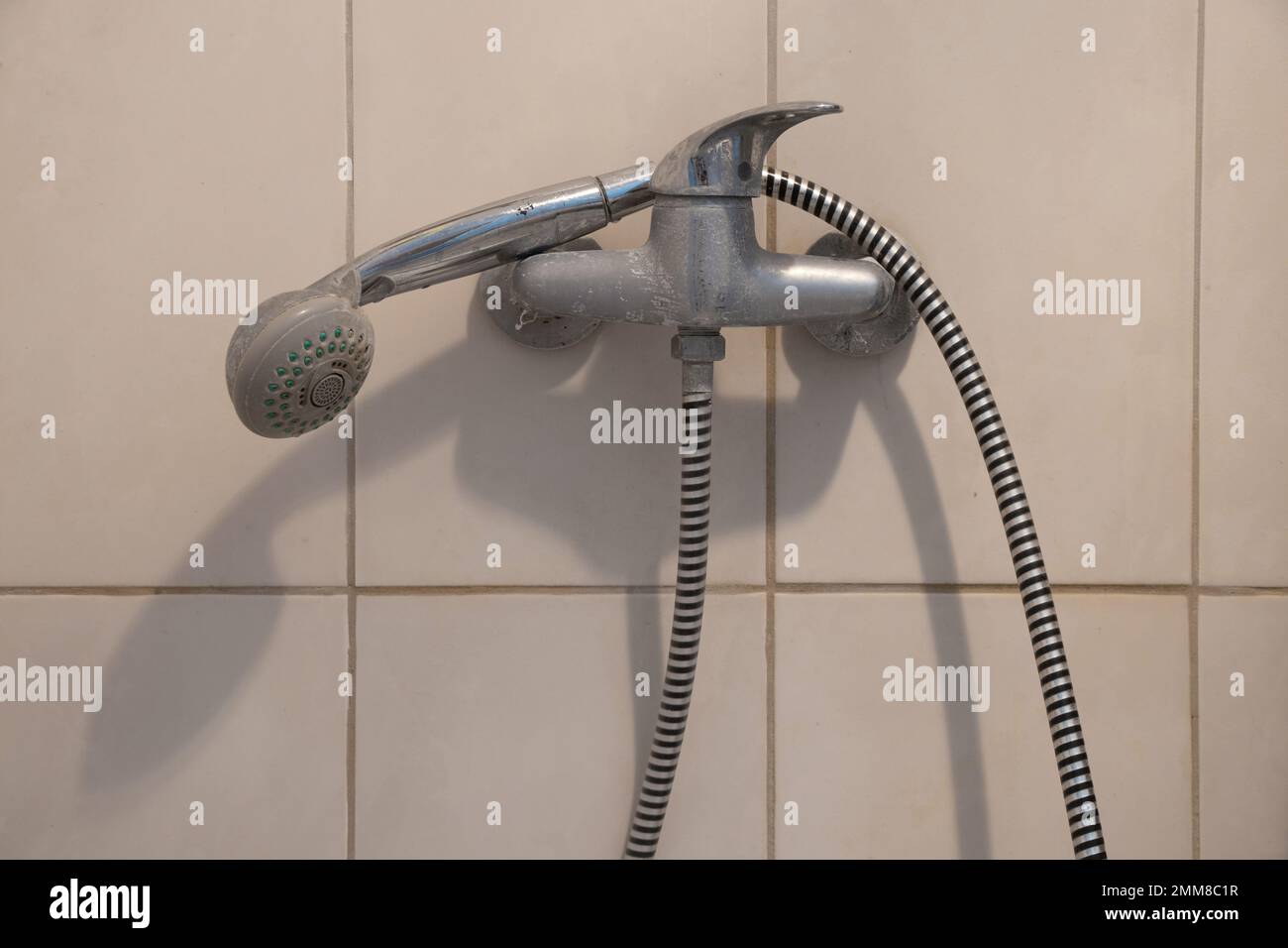robinet de douche avec une tête d'arrosage sur un long tuyau dans la salle de bains, cabine de douche avec un robinet Banque D'Images