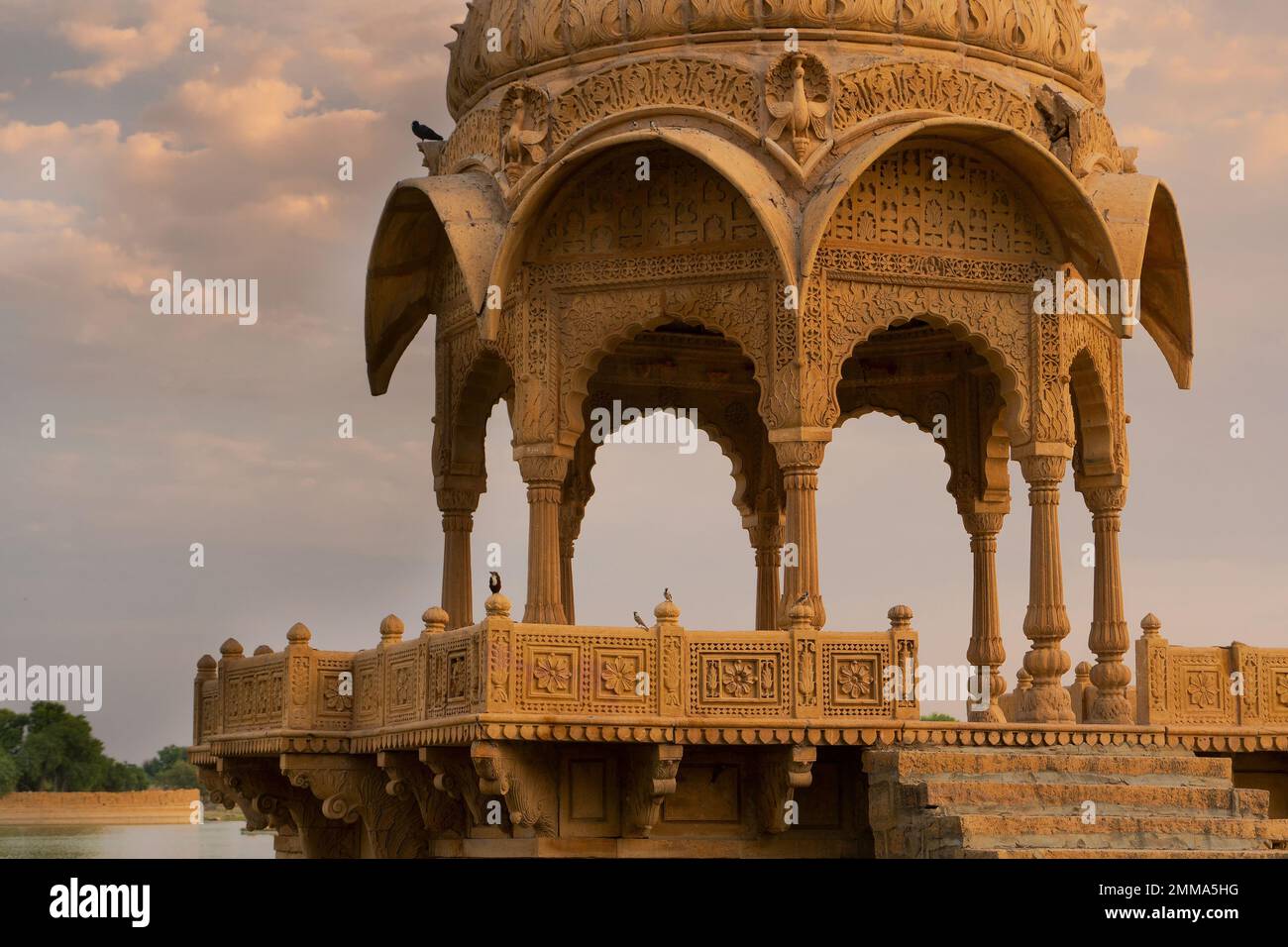 Vue rapprochée de Chhatris et sanctuaires de dieux hindous et déesses au lac Gadisar, Jaisalmer, Rajasthan, Inde. Architecture indo-islamique, coucher de soleil. Banque D'Images