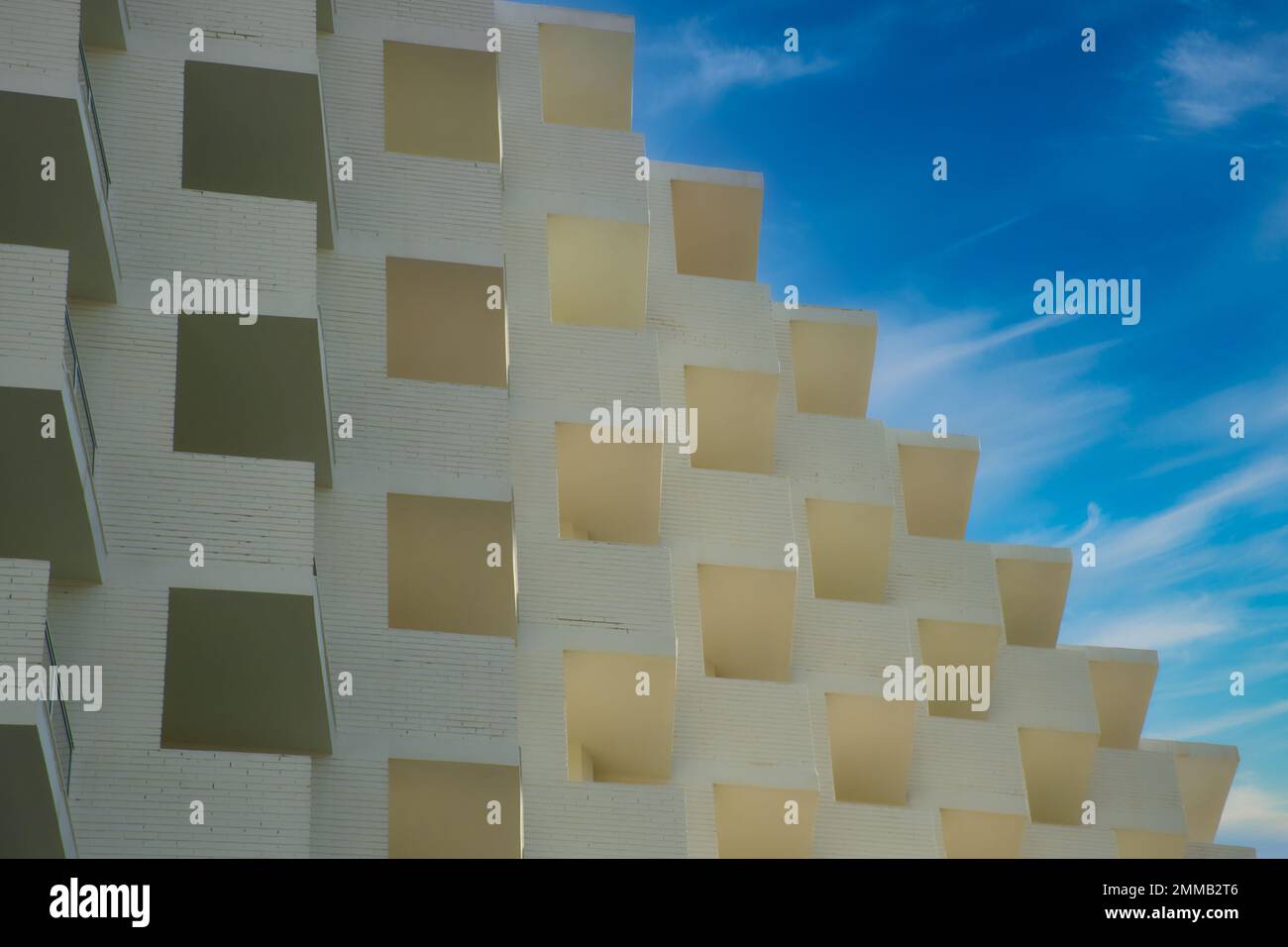 Fragment de brique blanche immeuble résidentiel d'appartements avec balcons sur fond bleu ciel Banque D'Images
