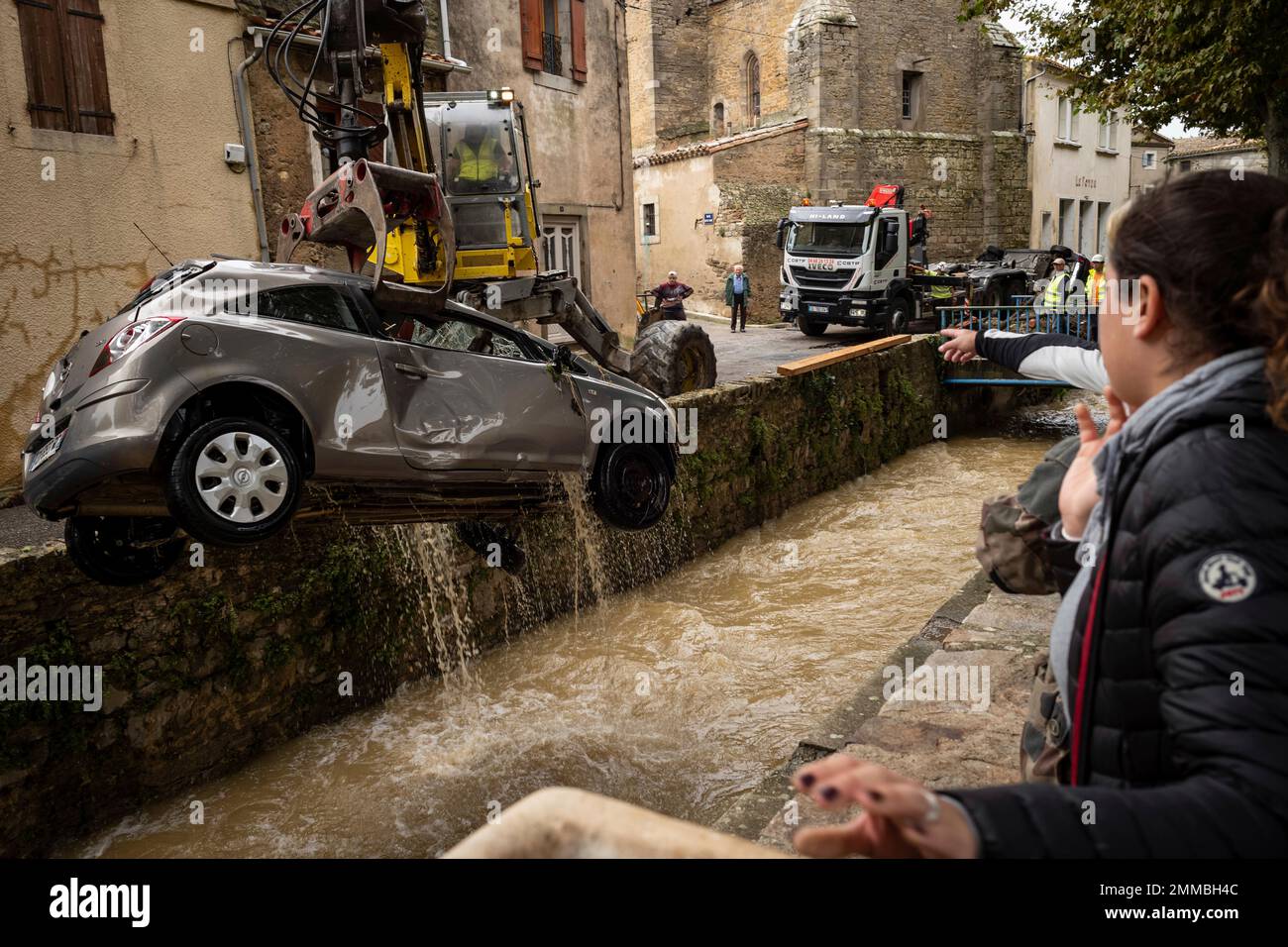 Residents watch workers pulling a car out of a torrent after flash floods in the town of Villegailhenc, southern France, Monday, Oct.15, 2018. Flash floods tore through towns in southwest France, turning streams into raging torrents that authorities said killed several people and seriously injured at least five others. (AP Photo/Fred Lancelot) Banque D'Images