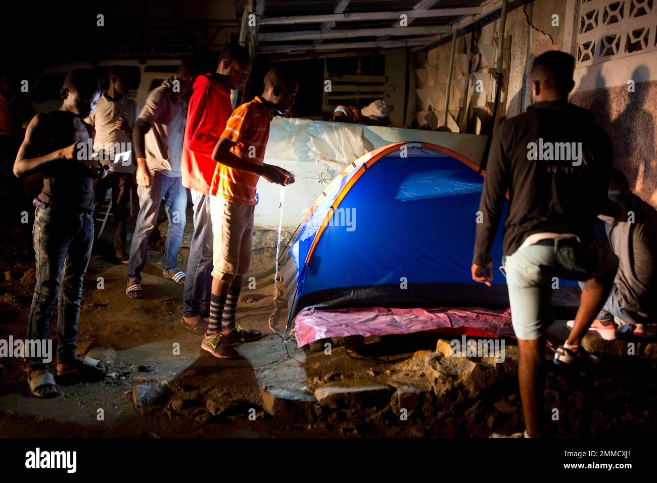 Residents set up a tent to sleep after a magnitude 5.9 earthquake the night before in Port-de-Paix, Haiti, Sunday, Oct. 7, 2018. The one-two punch of the magnitude 5.9 earthquake in northern Haiti on Saturday that destroyed houses and killed at least a dozen of people followed by a strong 5.2 magnitude aftershock on Sunday has residents worried about returning to their cracked cinderblock homes for fear they will collapse. ( AP Photo/Dieu Nalio Chery) Banque D'Images