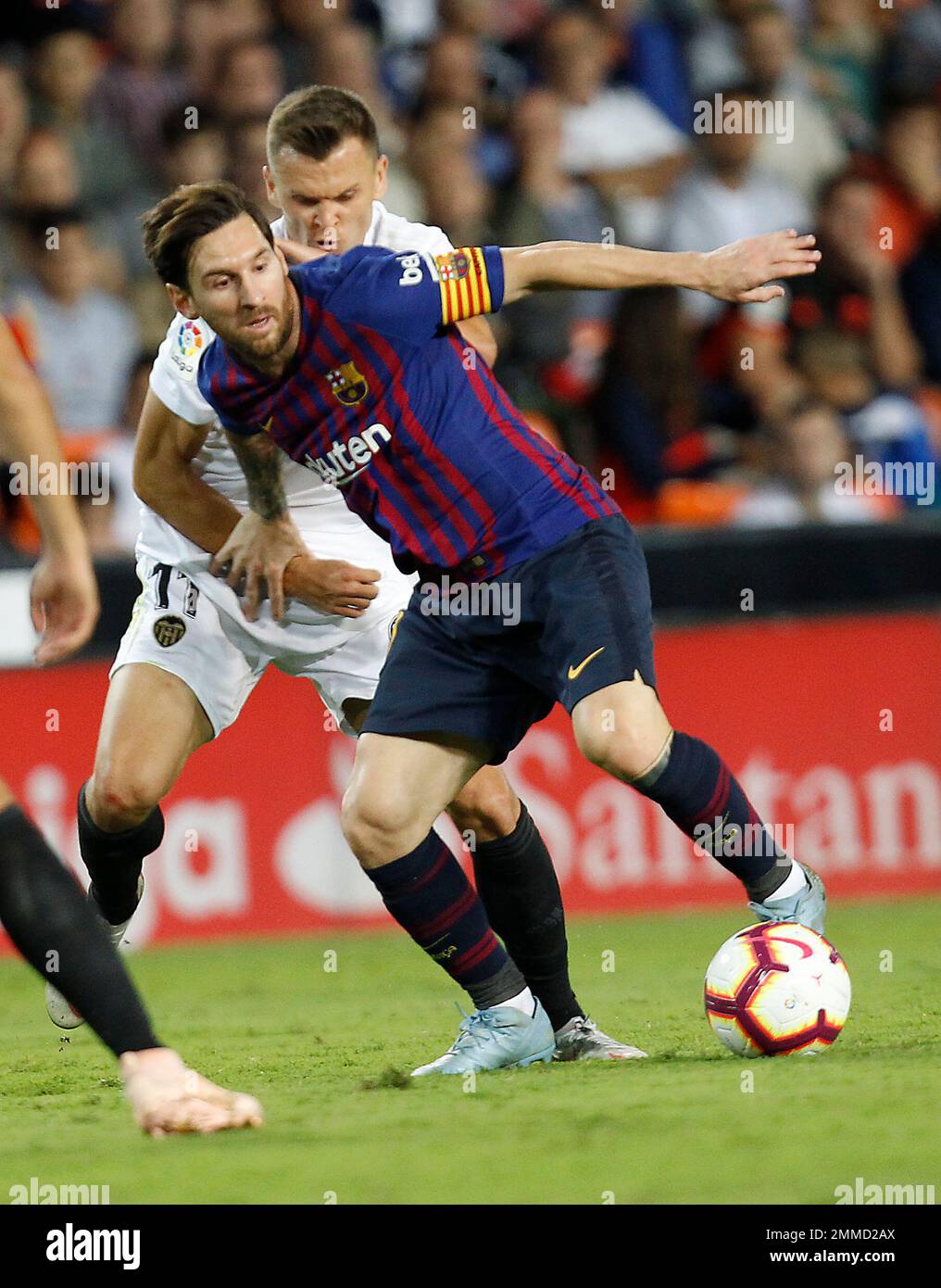 Barcelona forward Lionel Messi, front, duels for the ball with Valencia midfielder Denis Cheryshev during the Spanish La Liga soccer match between Valencia and Barcelona, at the Mestalla stadium in Valencia, Spain, Sunday, Oct. 7, 2018. (AP Photo/Alberto Saiz) Banque D'Images
