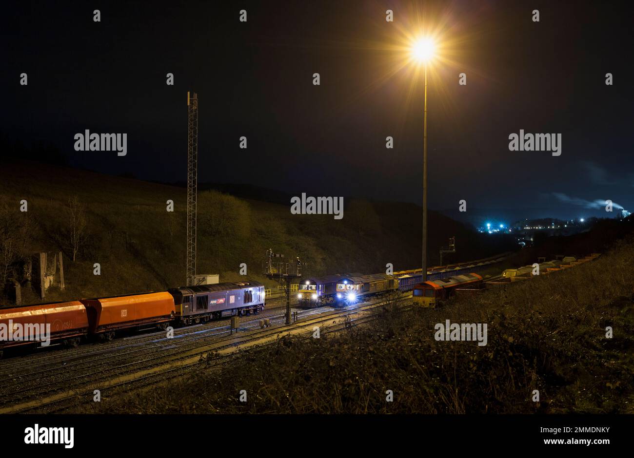 DB Cargo et GB Rail Freight classe 60 et 66 locomotives diesel transportant des trains de marchandises à Peak Forest, Derbyshire la nuit sous les projecteurs Banque D'Images