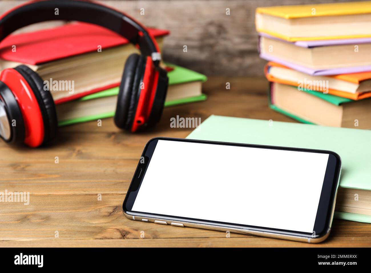Smartphone moderne avec écran vierge et livres sur table en bois, gros plan. Espace de conception Banque D'Images