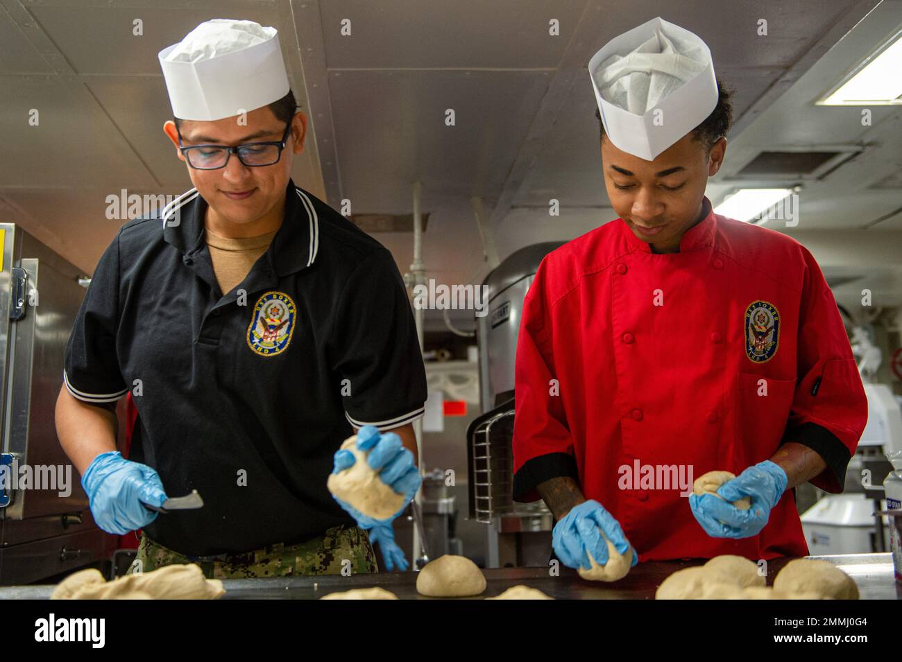 19 septembre 2022 – technicien en électronique 3rd classe Javier Varela, à gauche, originaire de long Beach, Californie, et spécialiste culinaire Seaman Rahsaan Sykes, originaire de Douglasville, Géorgie, tous deux affectés au navire d'assaut amphibie USS Boxer (LHD 4), pétrir la pâte dans l'atelier de cuisson en préparation du déjeuner. Boxer est un navire d'assaut amphibie de classe Wasp, qui a été porté à San Diego. Banque D'Images