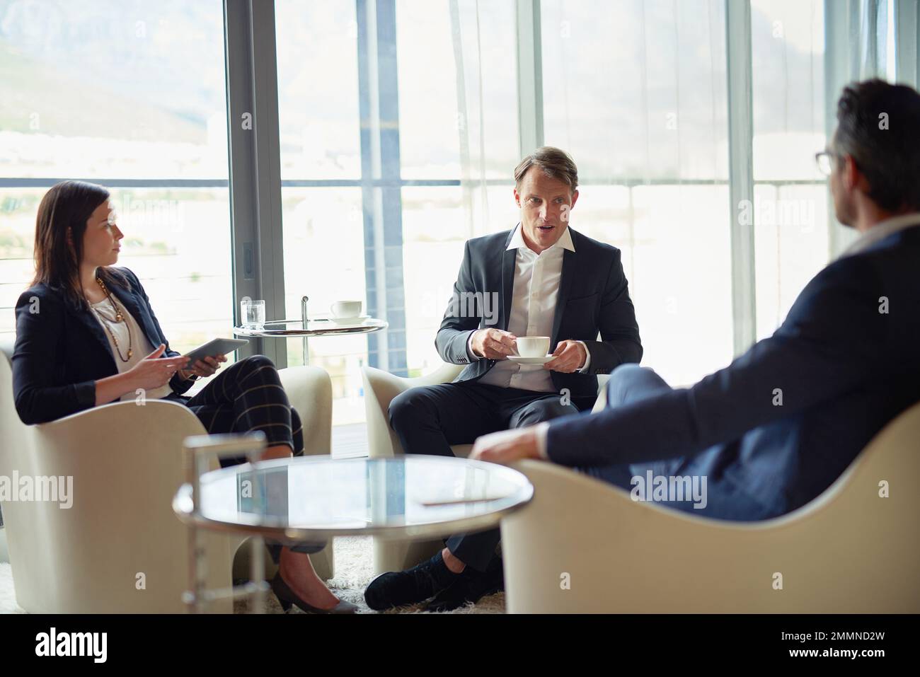 N'importe quel endroit est un bon endroit pour une discussion. trois hommes d'affaires parlent dans un bureau d'entreprise. Banque D'Images