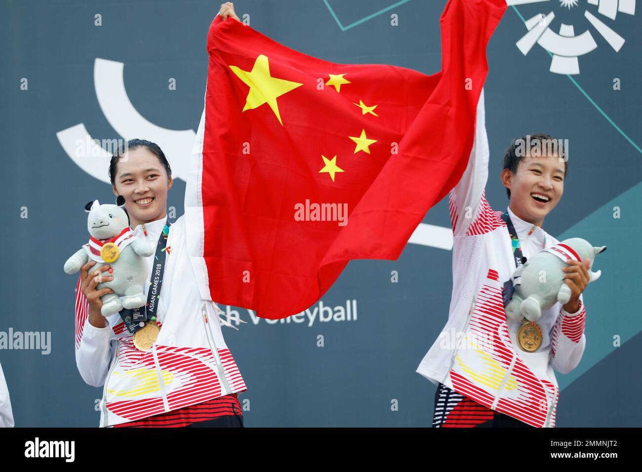 China's Xia Xinyi, right, and her teammate Wang Fan celebrates during the awards ceremony for women's beach volleyball gold medal match at the 18th Asian Games in Palembang, Indonesia, Monday, Aug. 27, 2018. (AP Photo/Vincent Thian) Banque D'Images