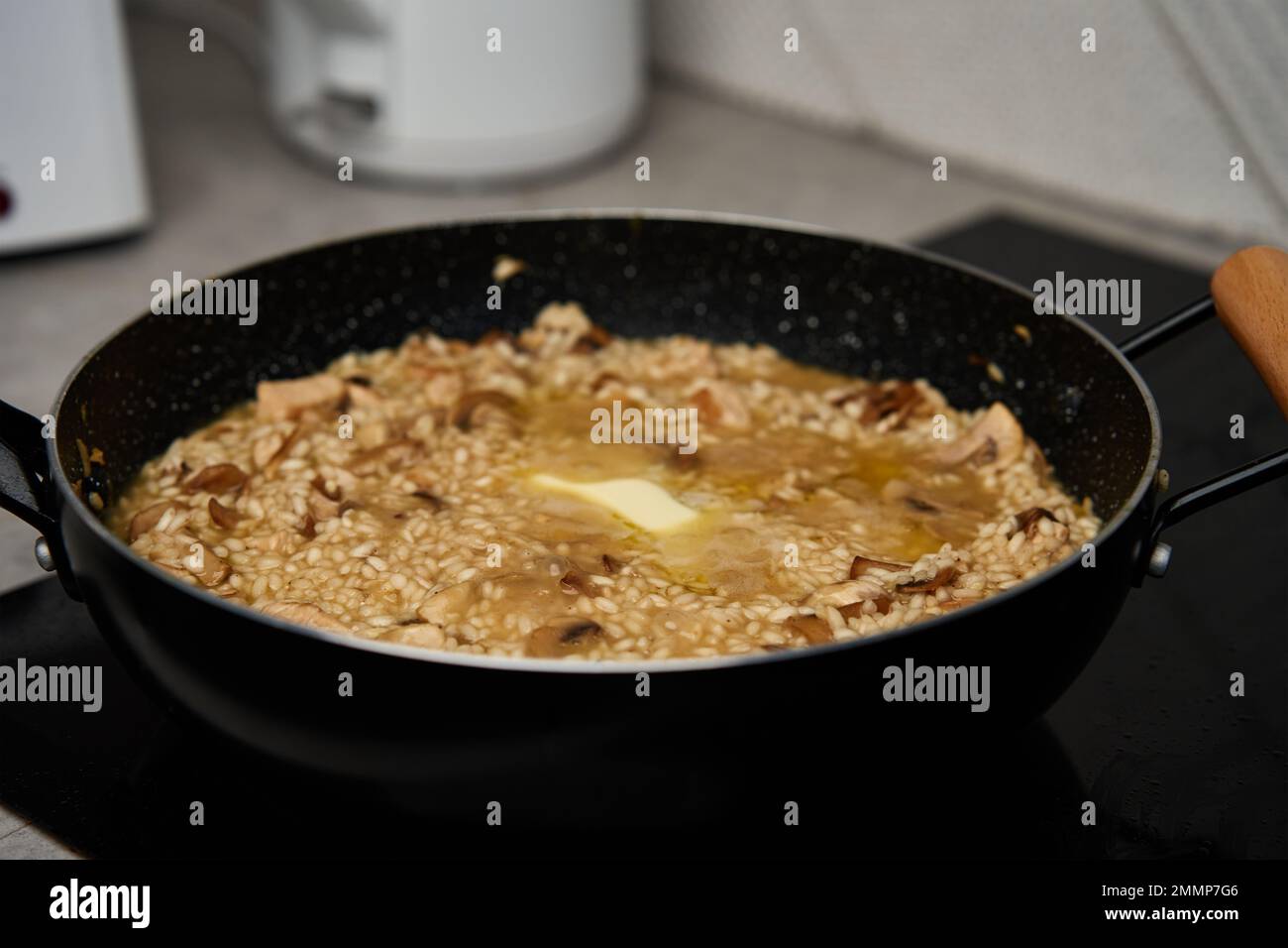 Processus de cuisson du risotto. Arborio riz et morceau de beurre dans poêle à frire dans la cuisine maison. Plat de cuisine italienne Banque D'Images