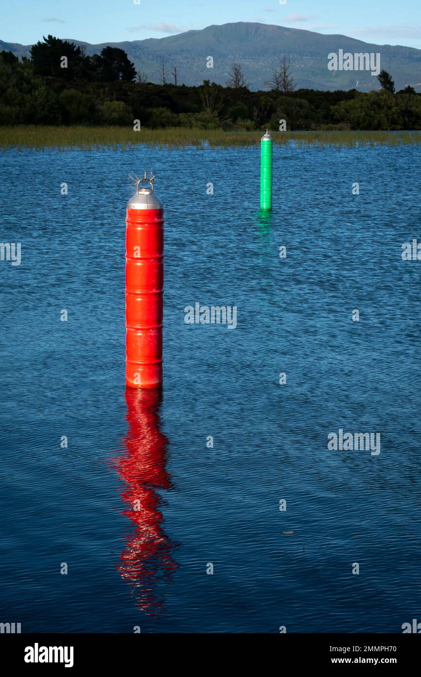 Marqueurs de navigation rouge et vert de chaque côté du canal de navigation menant à la marina de Motuoapu, lac Taupo, Île du Nord, Nouvelle-Zélande Banque D'Images