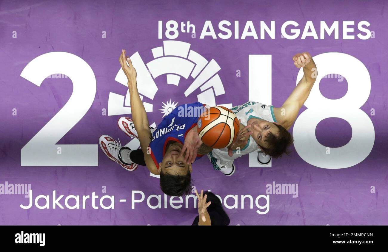 In this Aug. 16, 2018, file photo, Philippines' John Erram, left, and Kazakhstan's Dmitriy Gavrilov jump for ball possession during their men's basketball match at the 18th Asian Games in Jakarta, Indonesia on Thursday, Aug. 16, 2018. (AP Photo/Aaron Favila, File) Banque D'Images