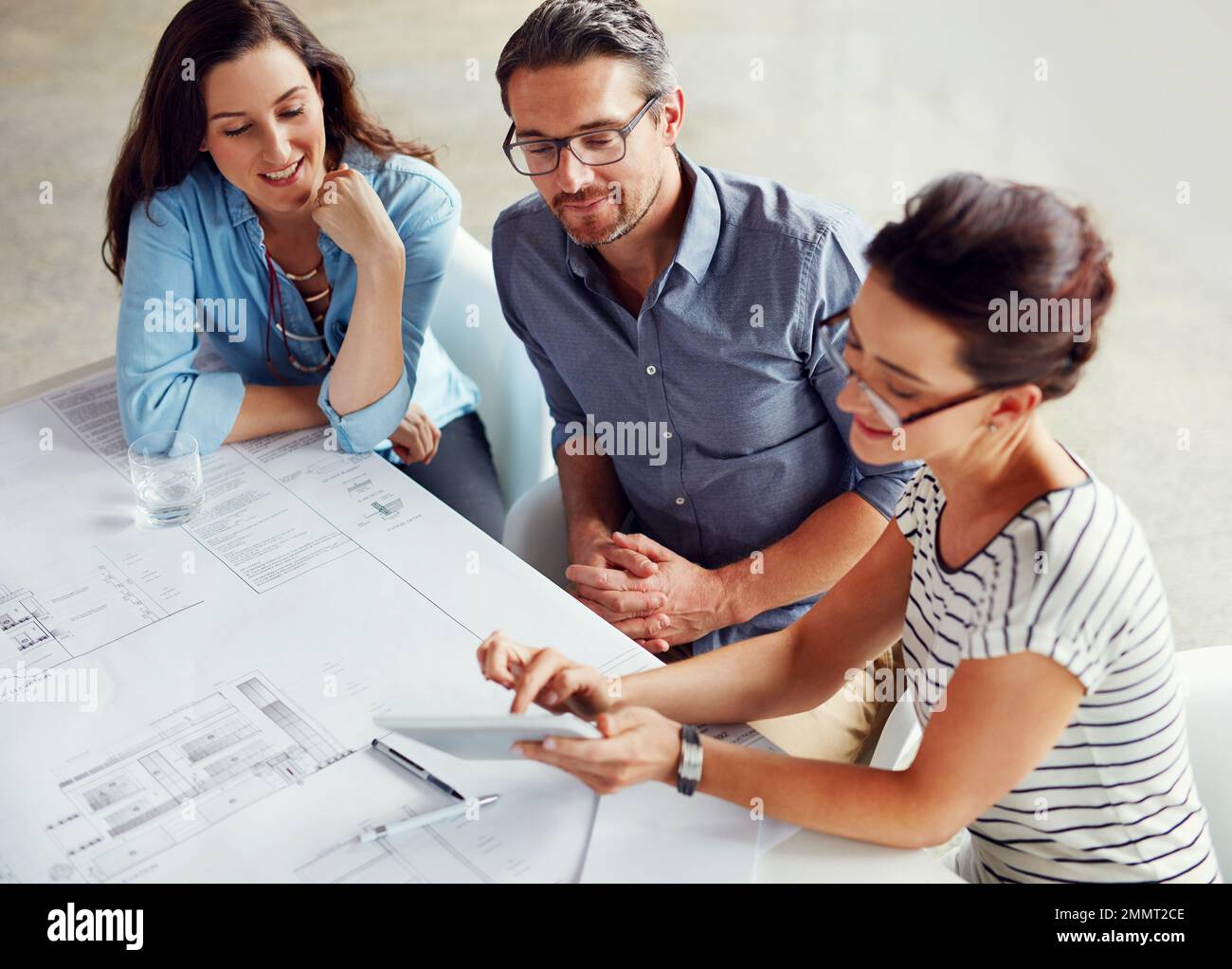 Faire des tombeaux de succès aujourd'hui. Un groupe de collègues ayant une réunion dans un bureau ouvert plan. Banque D'Images