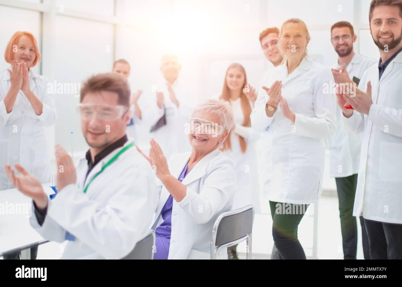 groupe de jeunes scientifiques félicitant leur collègue d'applaudissements . concept de succès Banque D'Images