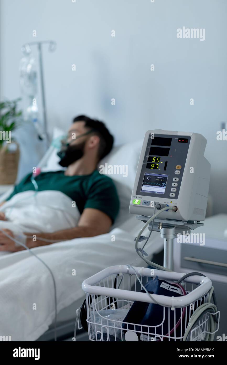 Un homme caucasien allongé au lit avec un masque à oxygène à l'hôpital Banque D'Images