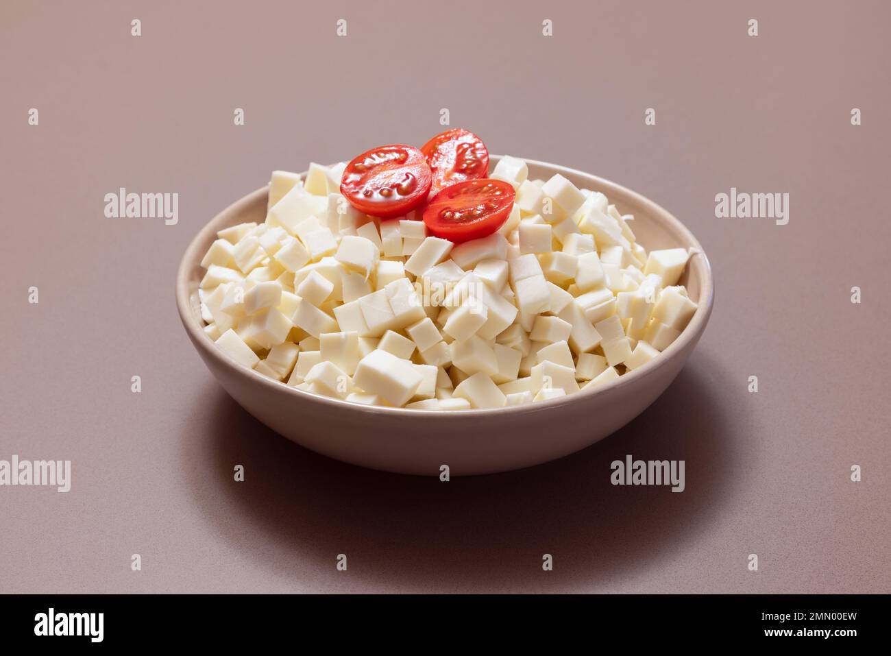 Un bol de mozzarella italienne en tranches prêt à préparer une pizza avec de petites tomates sur le dessus Banque D'Images