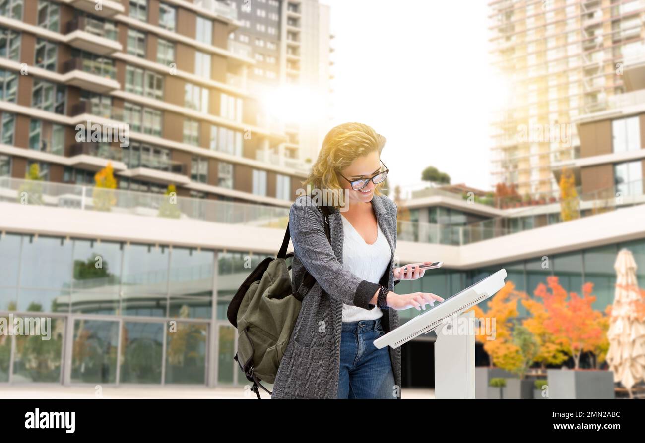 Femme utilisant l'écran numérique sur la rue de la ville. Concept Banque D'Images