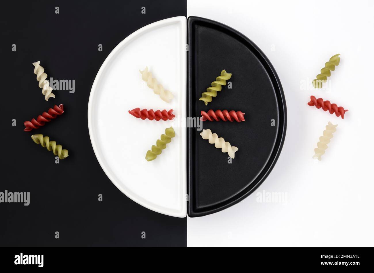 Riz aux légumes les pâtes en spirales sont disposées sur des assiettes noires et blanches Banque D'Images