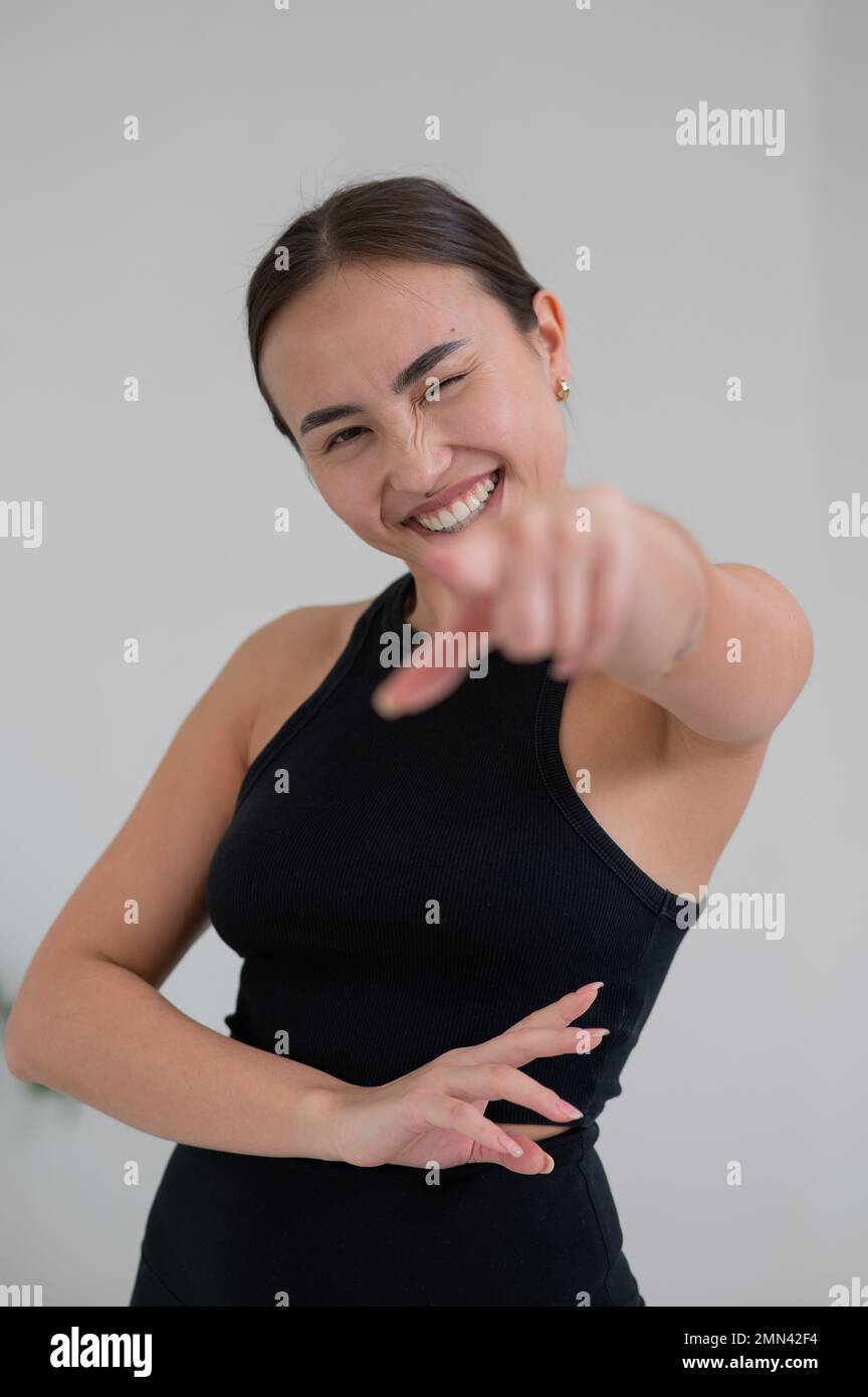 Femme asiatique souriante pointant son doigt sur fond blanc. Banque D'Images Femme asiatique souriante pointant son doigt sur fond blanc. Banque D'Images