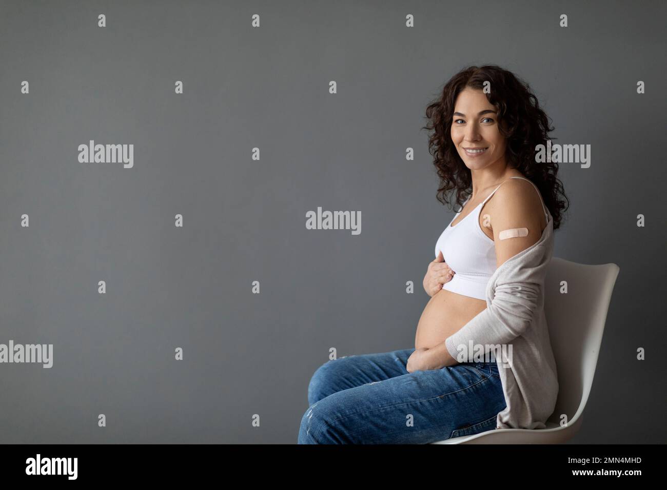 Portrait de la jeune femme enceinte souriante posant après la vaccination contre le coronavirus Banque D'Images