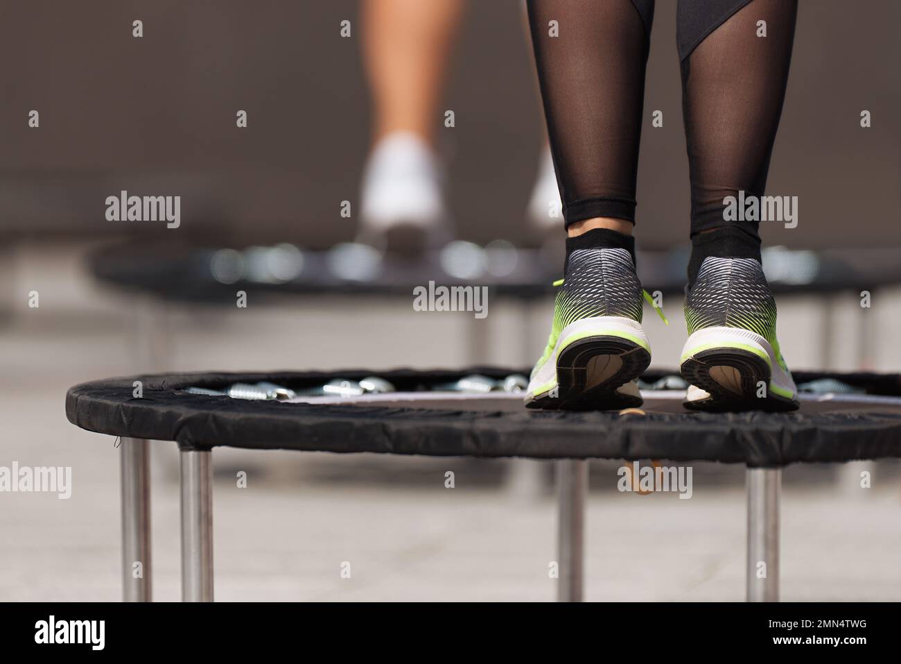 Les femmes de fitness sautant sur de petits trampolines, s'entraîner sur le rétracteur Banque D'Images