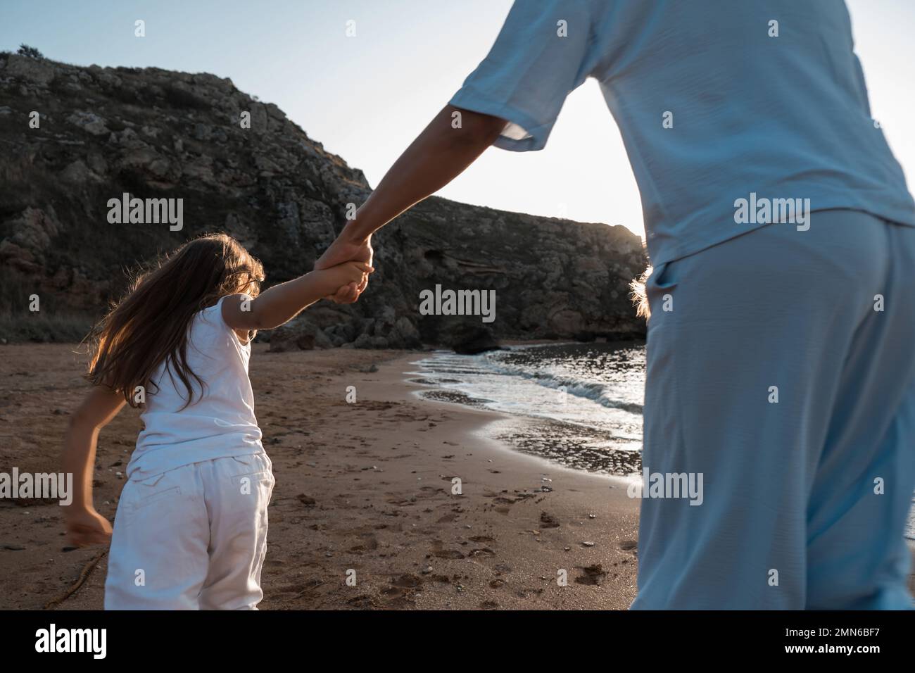 L'amour de la mère. Maman embrasse ses filles, embrasse et joue, tendresse et soin. Famille sympathique à la maison et en vacances. Banque D'Images