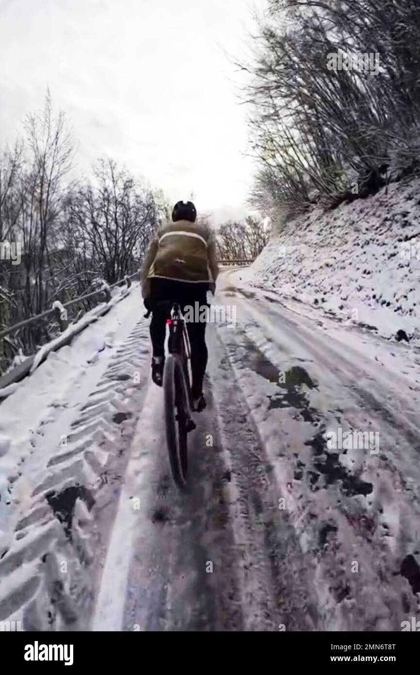 Les cyclistes se promène sur une route de montagne enneigée Banque D'Images
