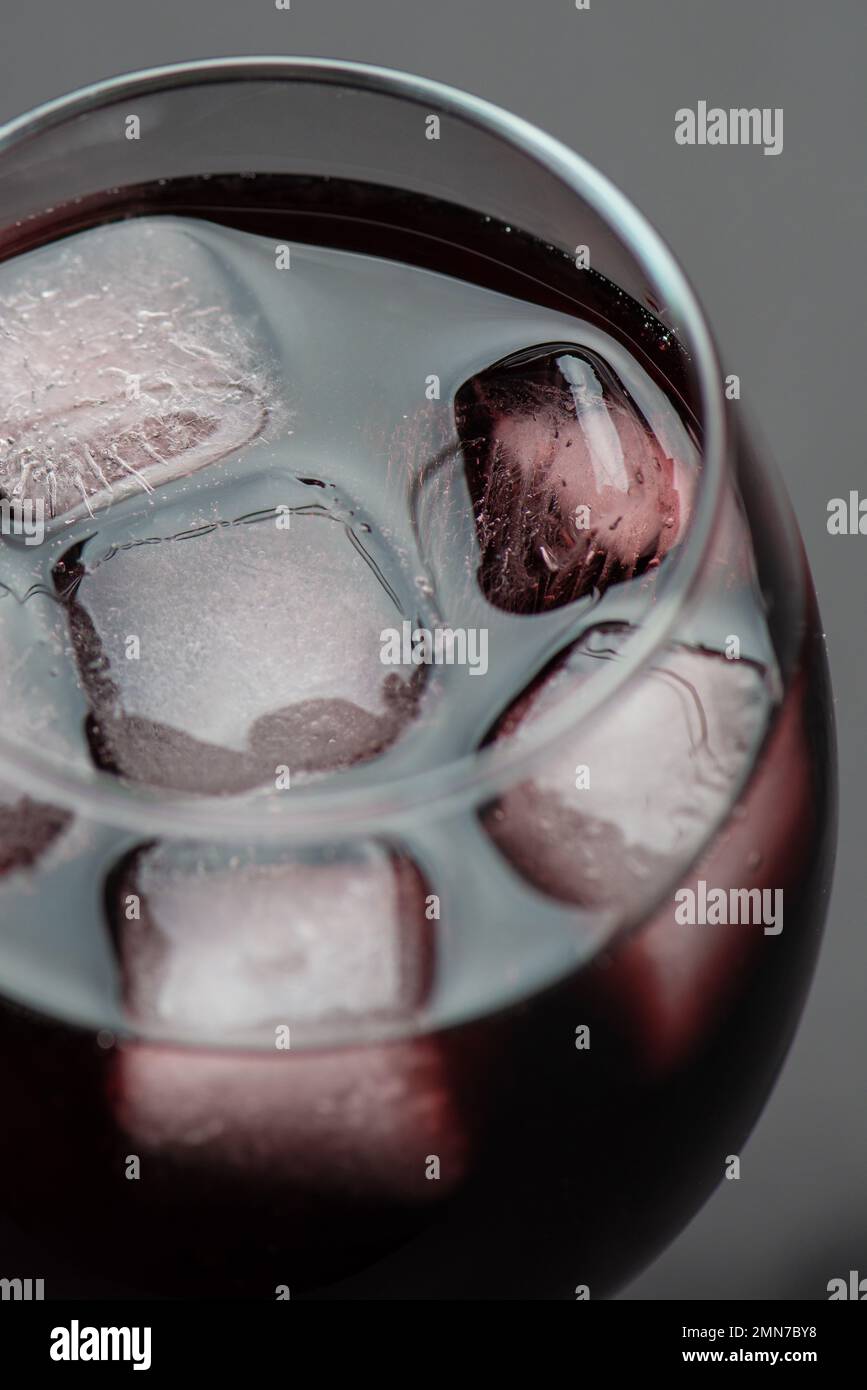 Verser du vin rouge dans un verre de glace avec des bulles, photo studio de haute qualité, gros plan Banque D'Images