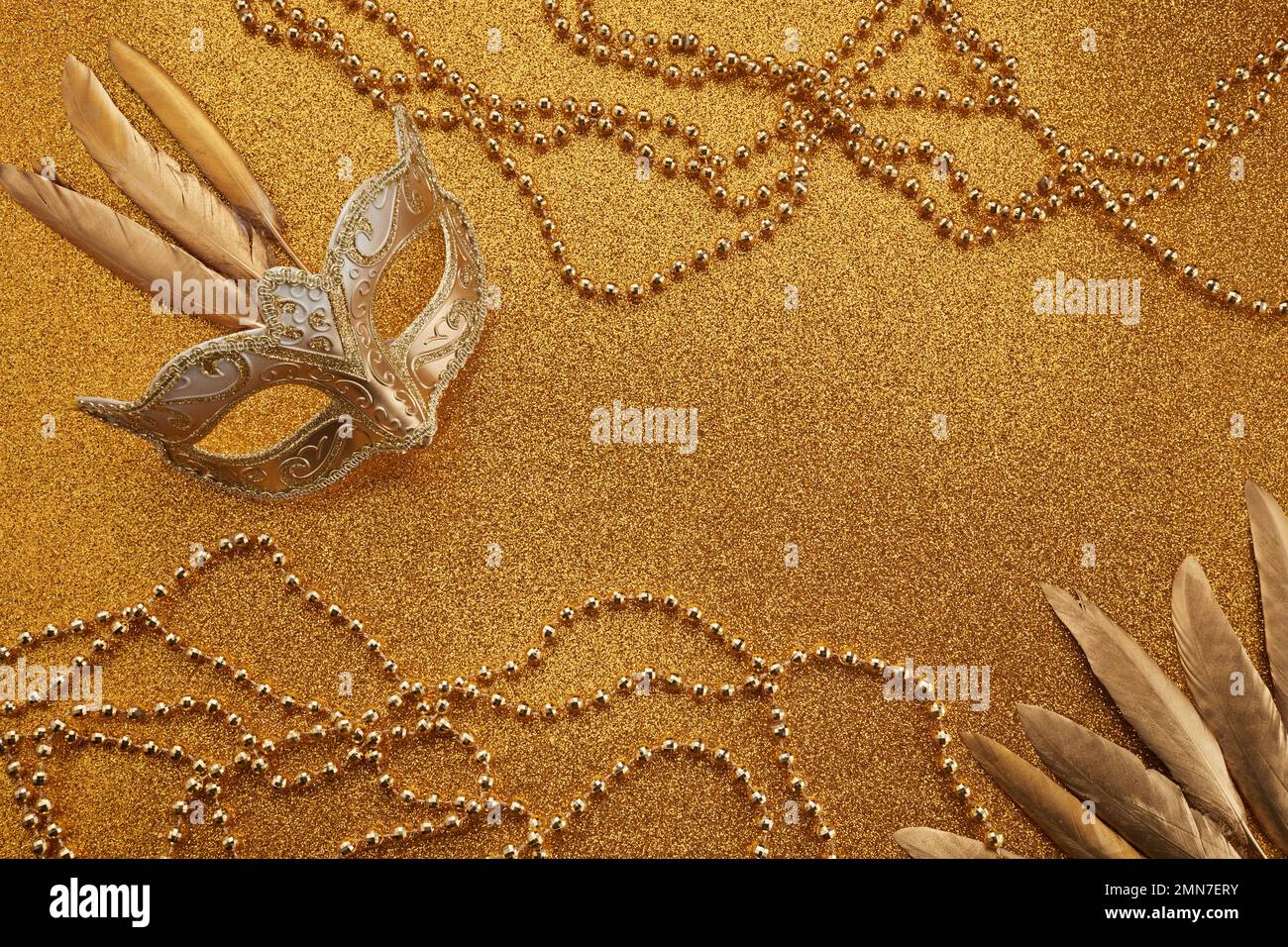 Mardi gras ou masque de carnaval avec perles sur fond doré brillant. Masque vénitien. Banque D'Images