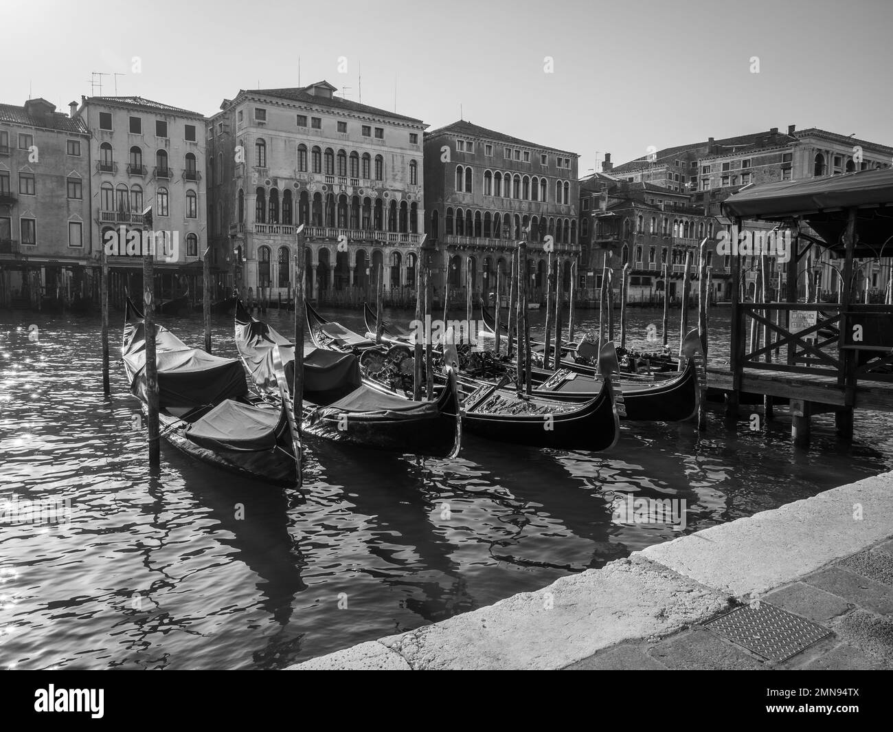 Photo en noir et blanc des gondoles amarrées dans le Grand canal de Venise, Italie. Concept du tourisme. Banque D'Images