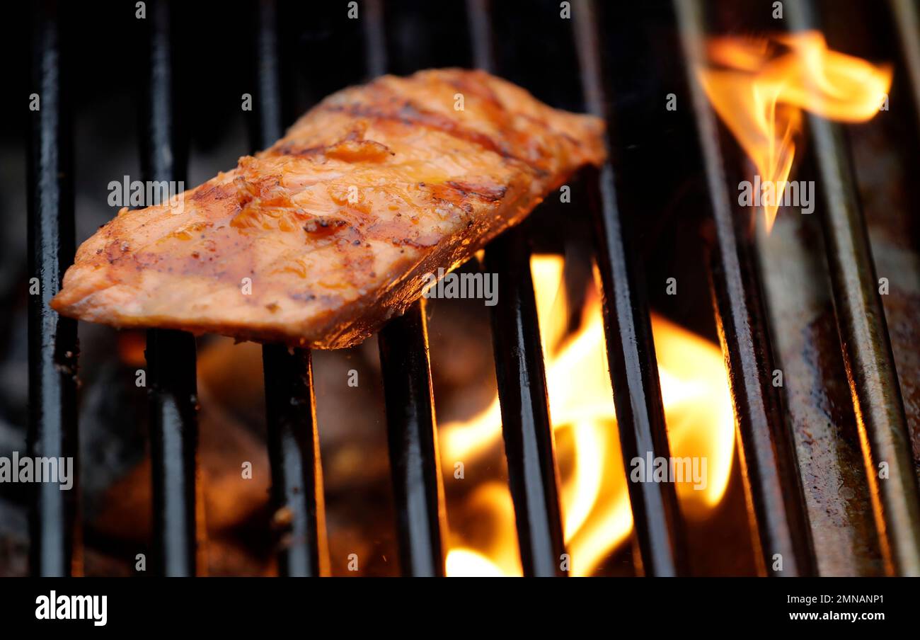 A piece of Copper River king salmon cooks on a grill, Friday, May 18