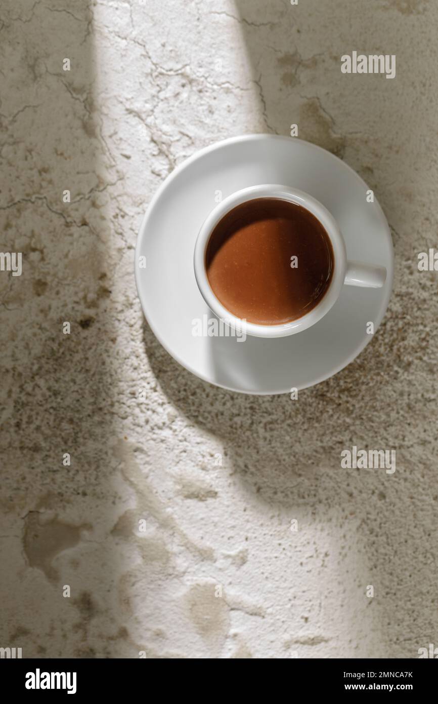 Boisson au cacao dans une tasse blanche sur fond blanc d'argile texturée, vue du dessus Banque D'Images