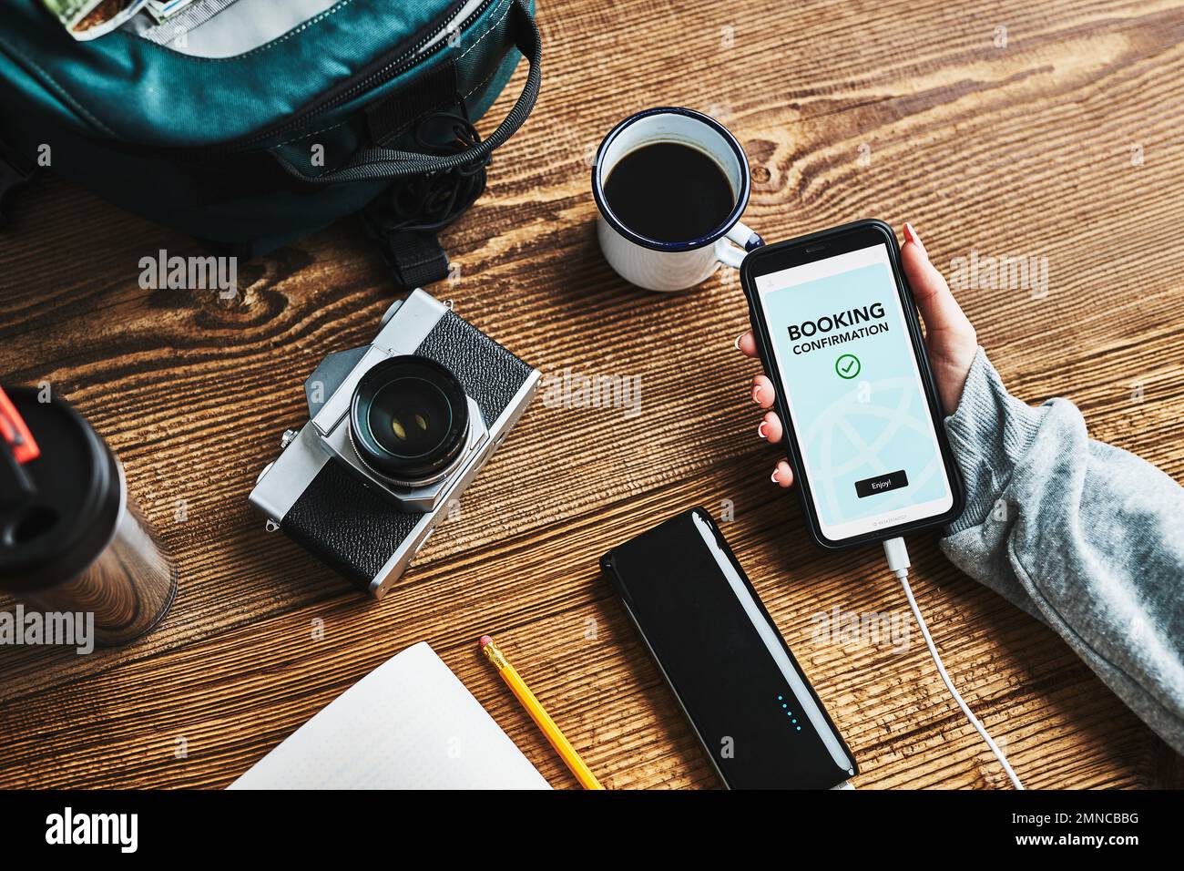 Femme qui prévoit de passer ses prochaines vacances. Réservation d'hôtel en ligne à l'aide d'un smartphone. Service de commande. Chargement du téléphone portable avec la batterie portable. Utilisation de la technologie wh Banque D'Images