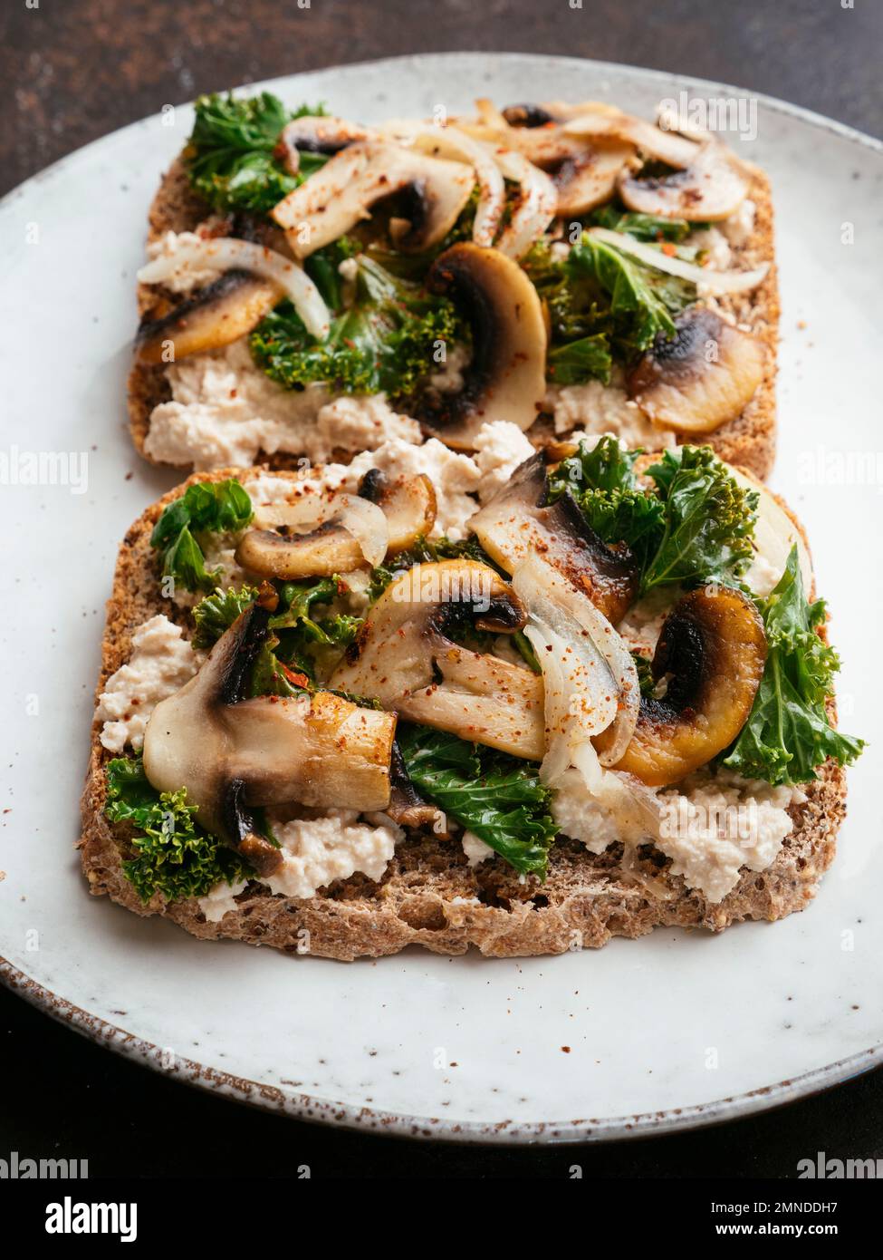 Ricotta végétalien maison, champignons et Kale sur le pain grillé Banque D'Images