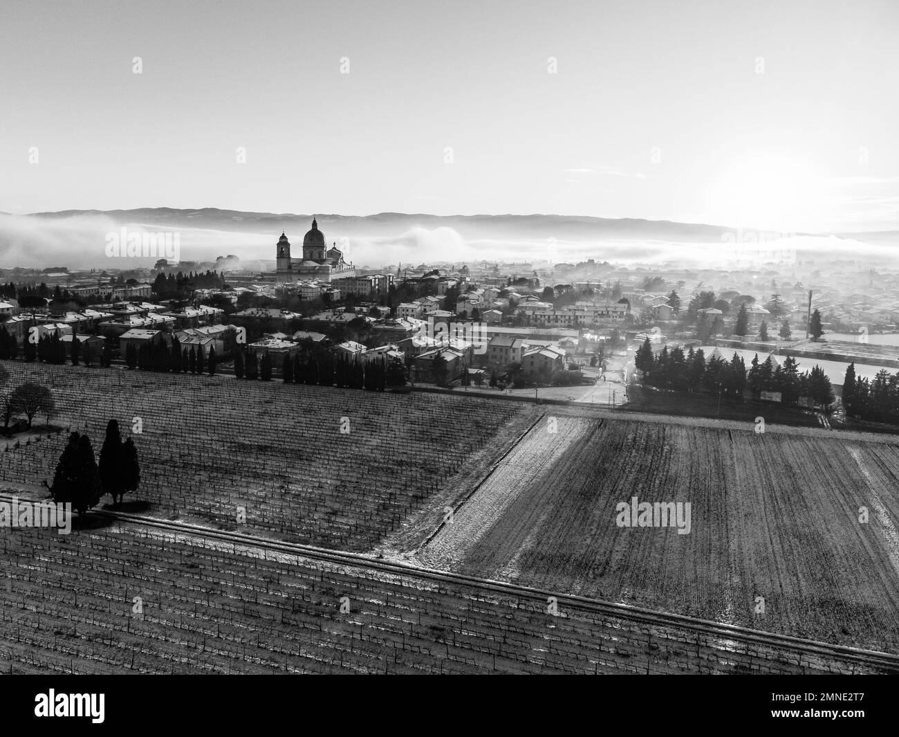 Vue aérienne de la ville de Santa Maria degli Angeli et de l'église au coucher du soleil, avec des prairies couvertes de neige Banque D'Images