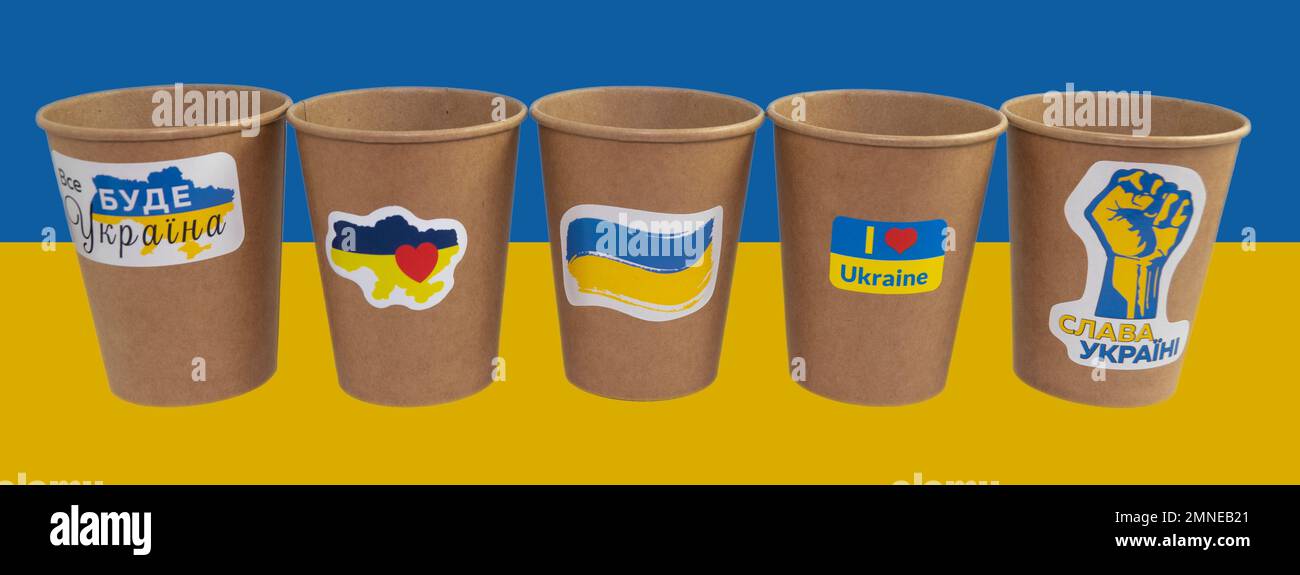 Cinq tasses en papier jetables de café avec des autocollants patriotiques. Traduction du texte sur les autocollants "tout sera l'Ukraine", "gloire à l'Ukraine" Banque D'Images