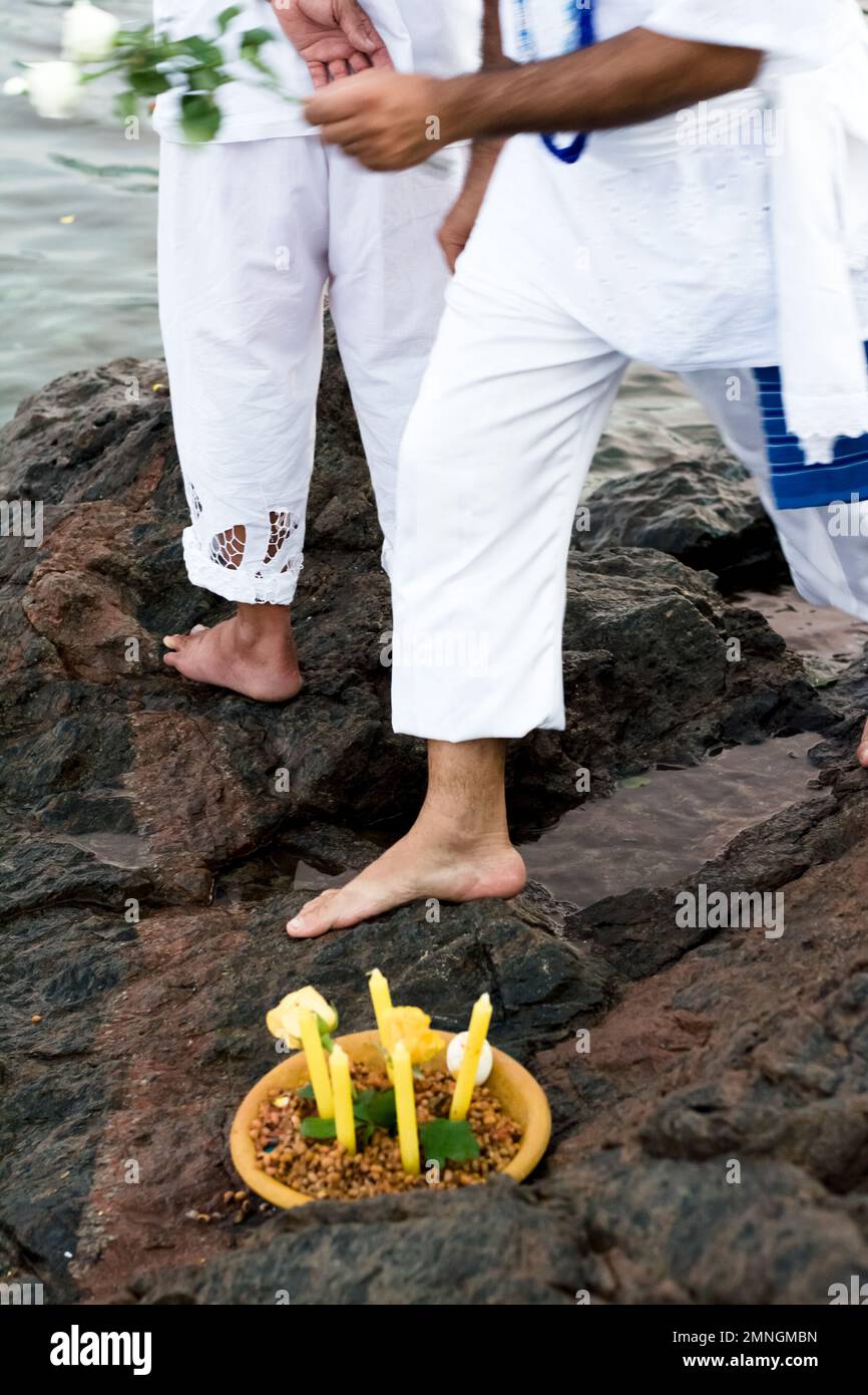 Salvador, Bahia, Brésil - 02 février 2017: Les admirateurs de Candomble sont vus sur un rocher sur la plage, rendant hommage à Iemanja avec des cadeaux le jour Banque D'Images